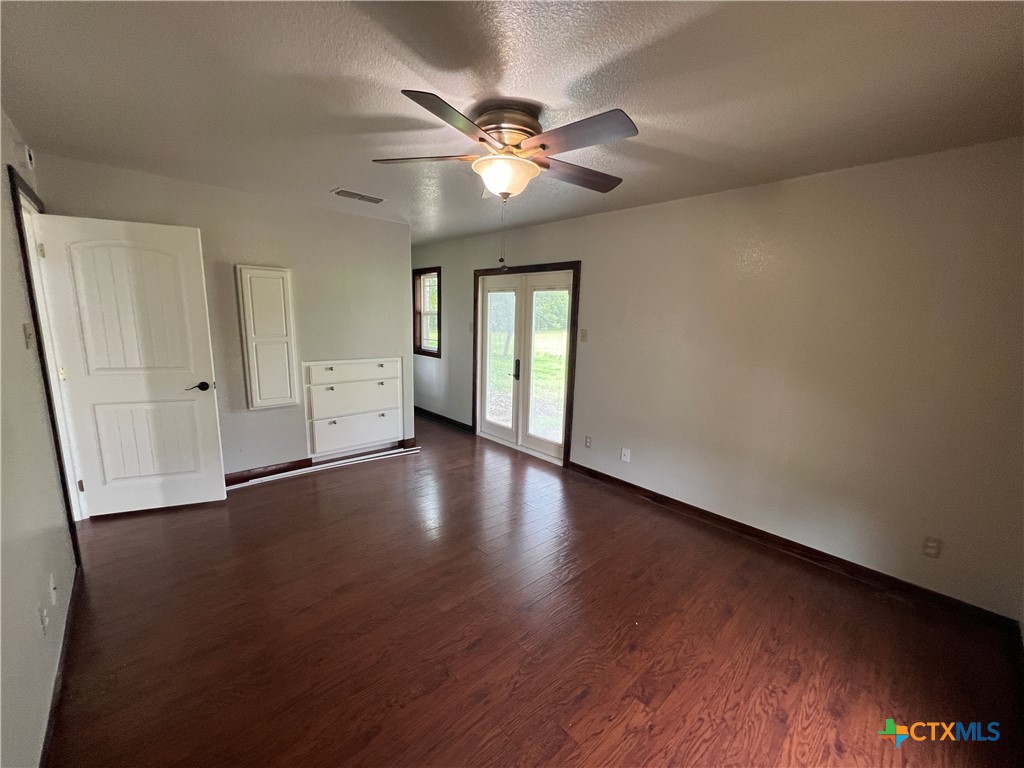 2955 East Amity Road Salado, TX 76571 - Photo 10 of 19 an empty room with wooden floor and windows