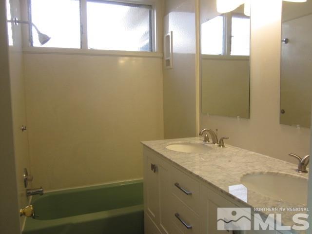 1440 Lander Street Reno, NV 89509 - Photo 8 of 22 a bathroom with a granite countertop sink and a mirror