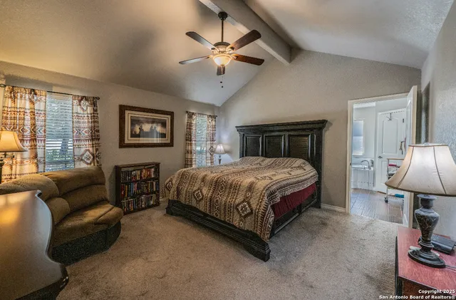 a spacious bedroom with a bed a couch and a chandelier