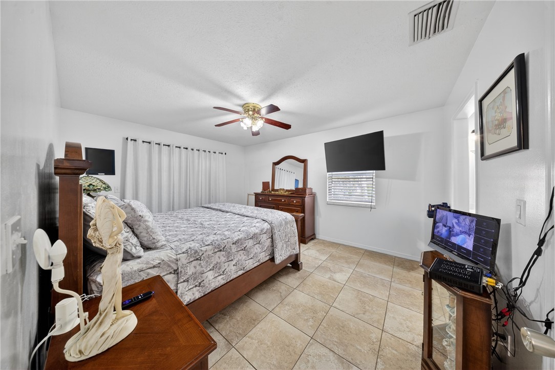 5809 Seagrape Drive Fort Pierce, FL 34982 - Photo 16 of 35 a bedroom with a bed and wooden floor