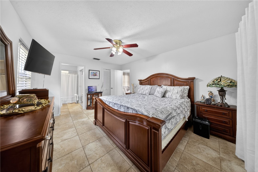 5809 Seagrape Drive Fort Pierce, FL 34982 - Photo 17 of 35 a bedroom with a bed and a flat screen tv