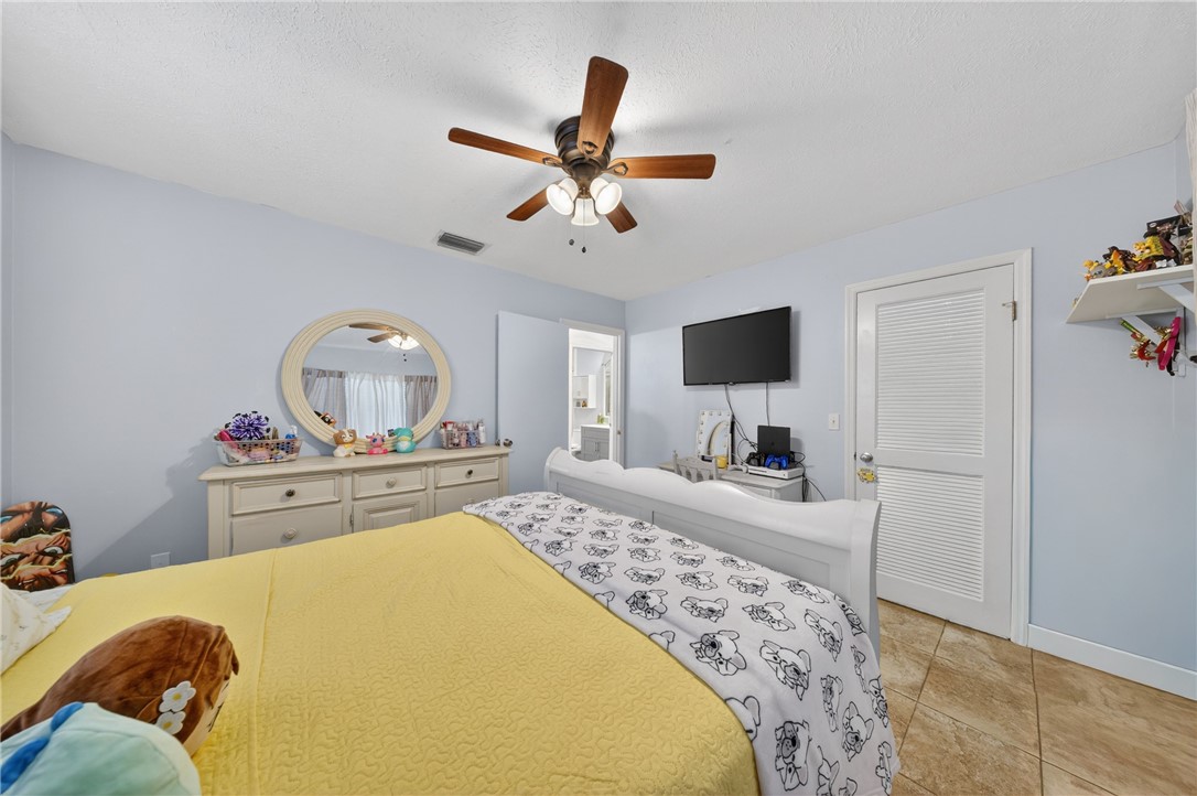 5809 Seagrape Drive Fort Pierce, FL 34982 - Photo 20 of 35 a bedroom with a bed and a flat screen tv