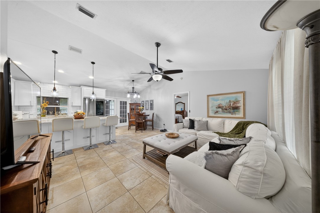 5809 Seagrape Drive Fort Pierce, FL 34982 - Photo 2 of 35 a living room with furniture kitchen view and a chandelier