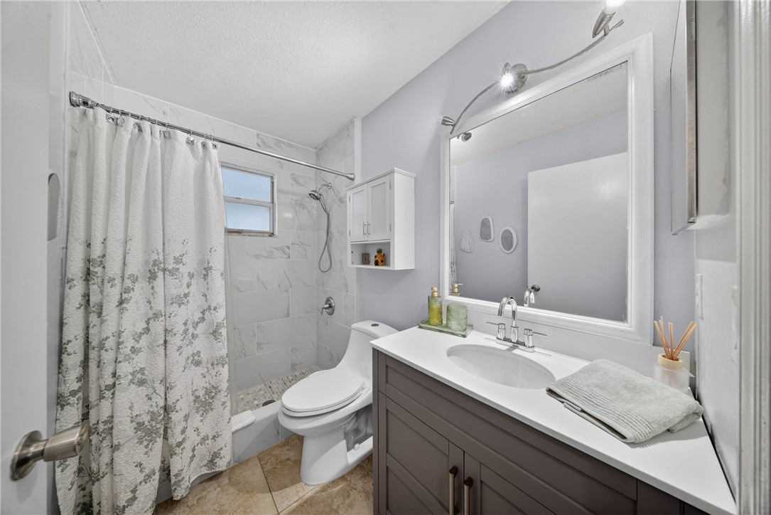 5809 Seagrape Drive Fort Pierce, FL 34982 - Photo 24 of 35 a bathroom with a double vanity sink toilet and shower