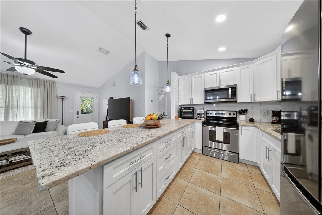 5809 Seagrape Drive Fort Pierce, FL 34982 - Photo 3 of 35 a kitchen with stainless steel appliances granite countertop a sink and microwave