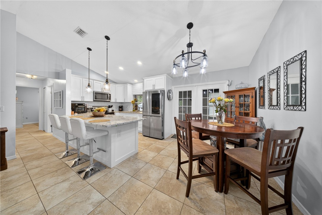 5809 Seagrape Drive Fort Pierce, FL 34982 - Photo 10 of 35 a view of kitchen with refrigerator stove dining table and chairs