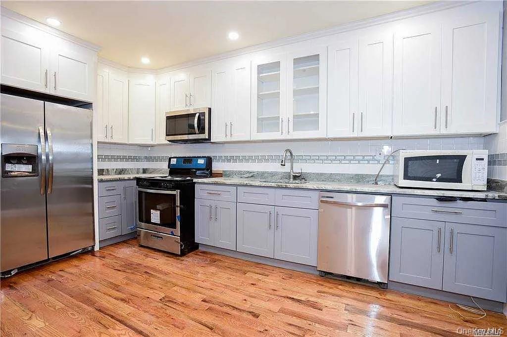 577 Logan Street Brooklyn, NY 11208 - Photo 3 of 8 a kitchen with stainless steel appliances granite countertop a refrigerator stove top oven and sink