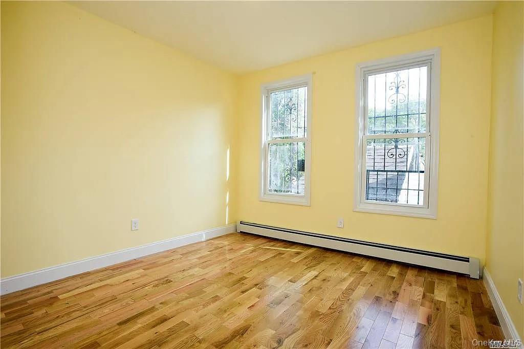 577 Logan Street Brooklyn, NY 11208 - Photo 5 of 8 a view of an empty room with wooden floor and a window