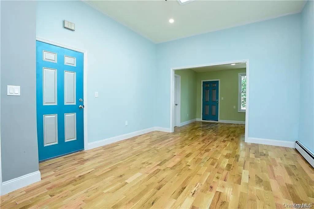 577 Logan Street Brooklyn, NY 11208 - Photo 7 of 8 a view of an empty room with wooden floor