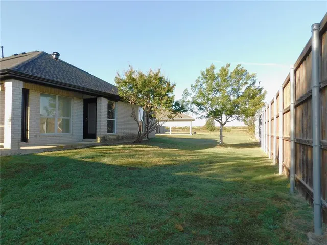 a front view of a house with a garden and trees