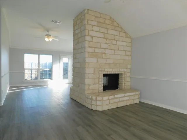 a view of a livingroom with wooden floor and a fireplace