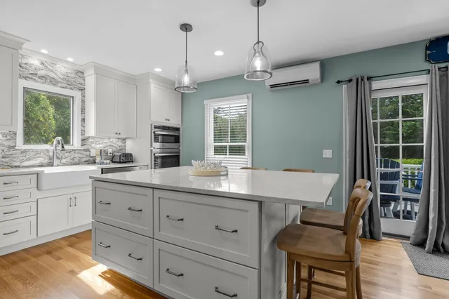 a kitchen with stainless steel appliances a dining table chairs stove and refrigerator