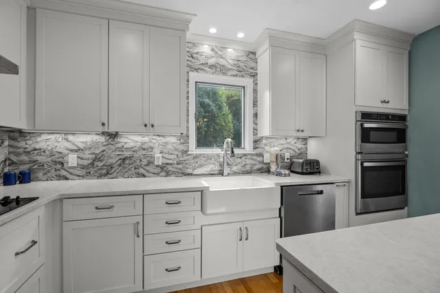 a kitchen with stainless steel appliances granite countertop a table and chairs in it