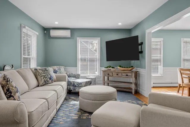 a dining room with wooden floor a chandelier a wooden table and chairs