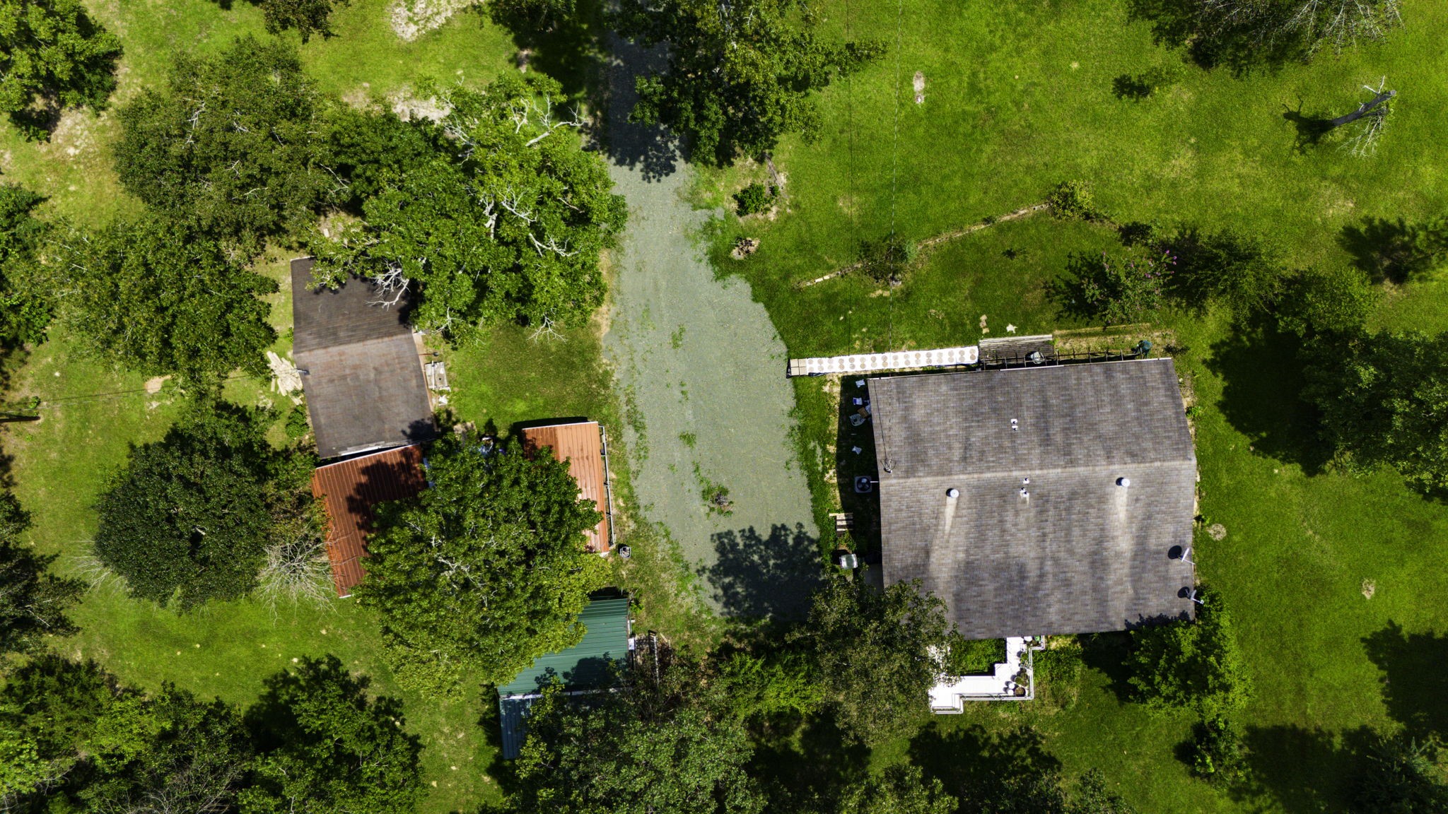 271 Ivanhoe Ranchettes Drive Ivanhoe, TX 75979 - Photo 3 of 40 This aerial photo showcases a spacious property with a main house guest house and outbuildings nestled in a lush, green landscape. The yard is expansive, featuring mature trees and is ideal for those seeking privacy and nature.