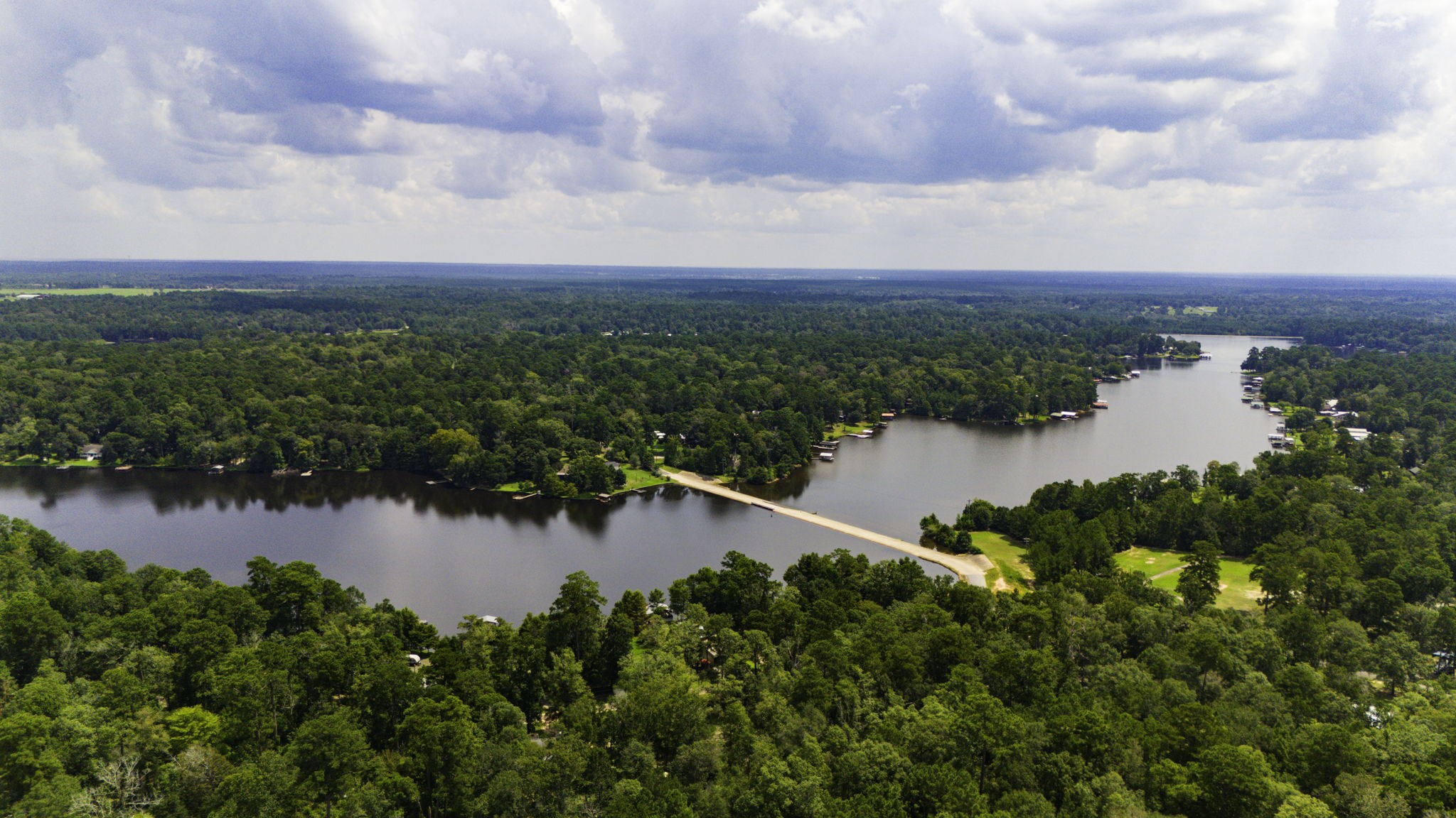 271 Ivanhoe Ranchettes Drive Ivanhoe, TX 75979 - Photo 4 of 40 Aerial view of a serene, wooded area featuring a large, scenic lake with a few homes nestled along its shoreline. Ideal for buyers seeking tranquility and natural beauty. This is one of 3 Lakes in the neighborhood.