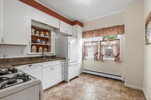 a kitchen with white cabinets and white appliances