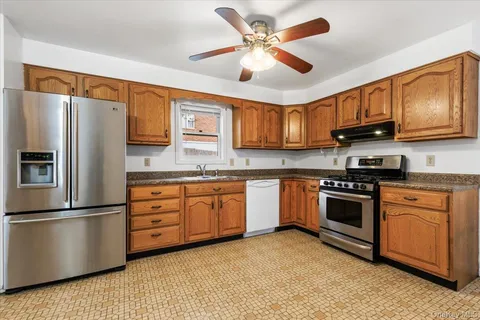 a kitchen with granite countertop stainless steel appliances and wooden cabinets