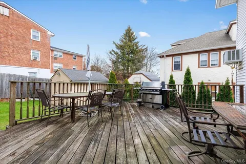 a view of a house with wooden deck outdoor seating