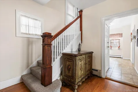 a view of a hallway with entryway wooden floor and windows