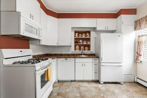 a kitchen with stainless steel appliances granite countertop a refrigerator sink and white cabinets