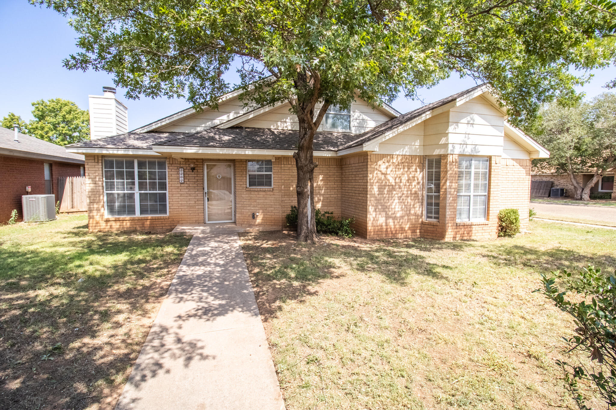 2202 93rd Place Lubbock, TX 79423 - Photo 1 of 11 a front view of a house with a yard and garage