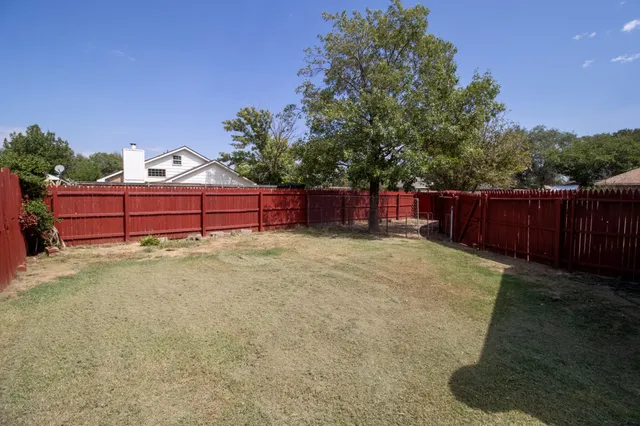 a view of a backyard with a small cabin and wooden fence