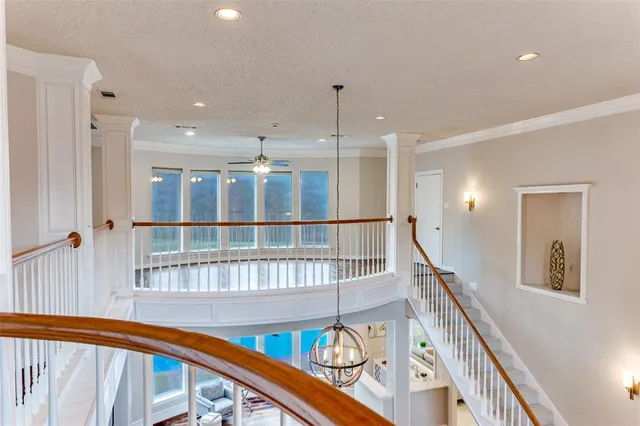 a view of a hallway with wooden floor and staircase