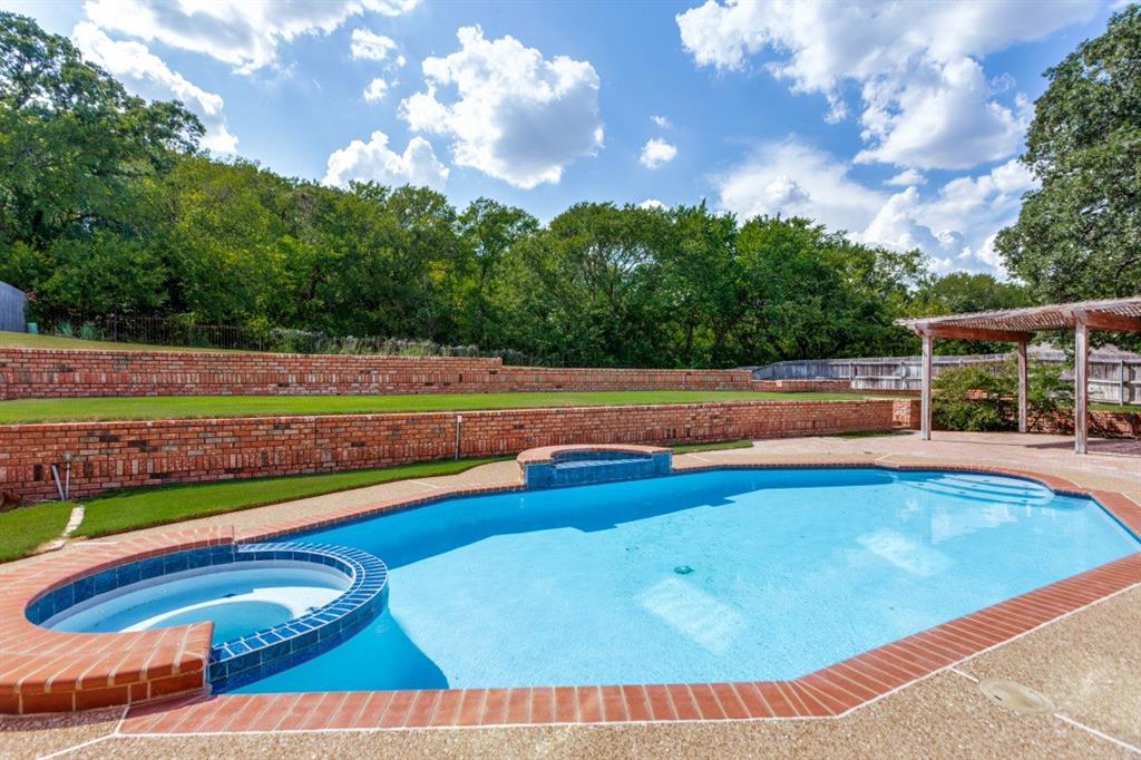 7702 Tillman Hill Road Colleyville, TX 76034 - Photo 4 of 26 a view of swimming pool with seating area and trees in the background