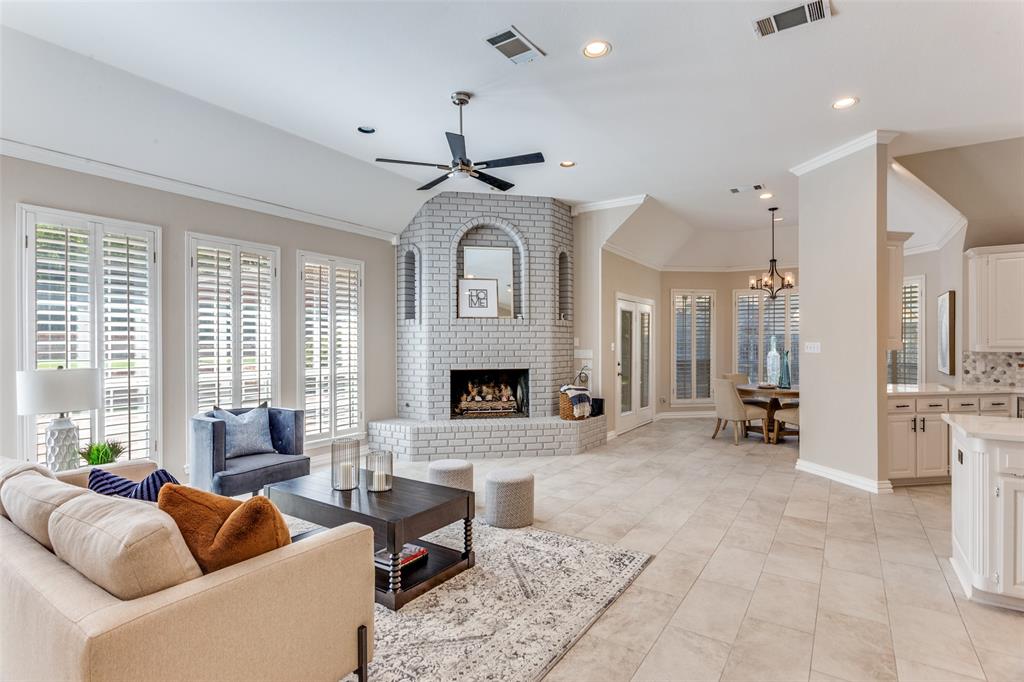 7702 Tillman Hill Road Colleyville, TX 76034 - Photo 9 of 26 a living room with furniture a fireplace and a chandelier