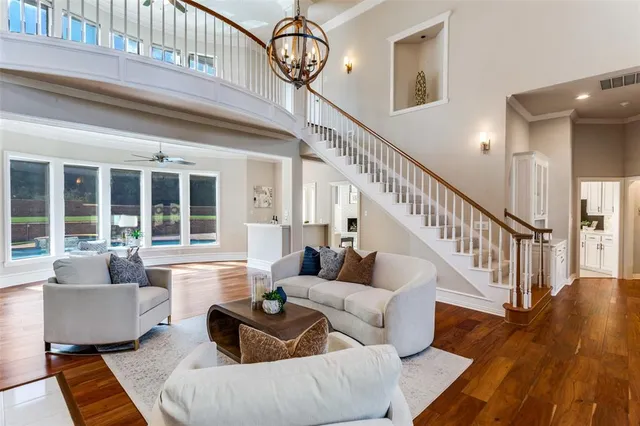 a living room with furniture a fireplace and a chandelier