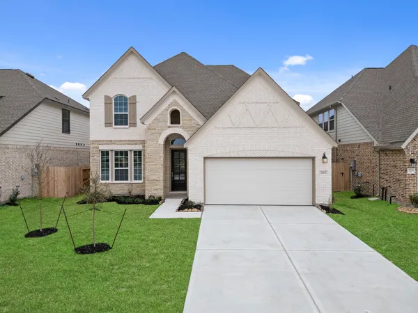 a front view of a house with a yard and garage