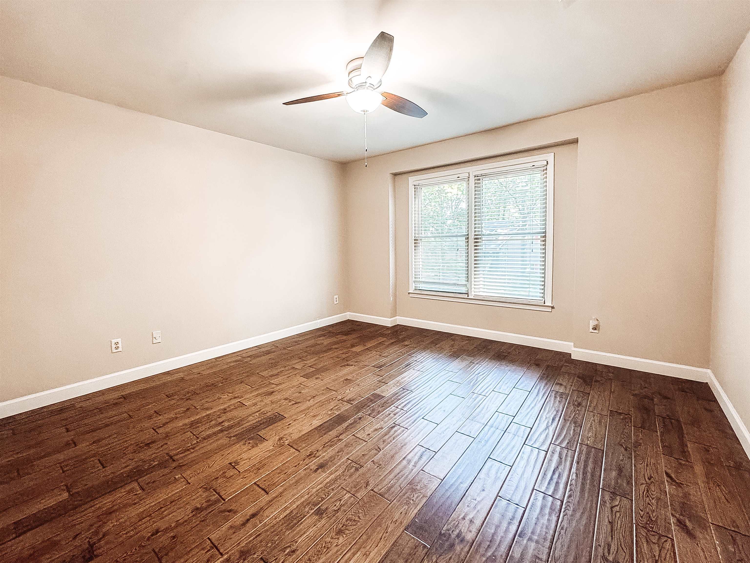 832 South Tree Drive Collierville, TN 38017 - Photo 25 of 40 Spacious room featuring wood-finish flooring, neutral-toned walls, a ceiling fan with light fixture, and a large window with blinds