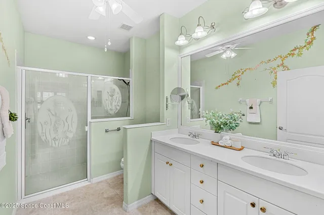 a bedroom with a bed and a chandelier fan