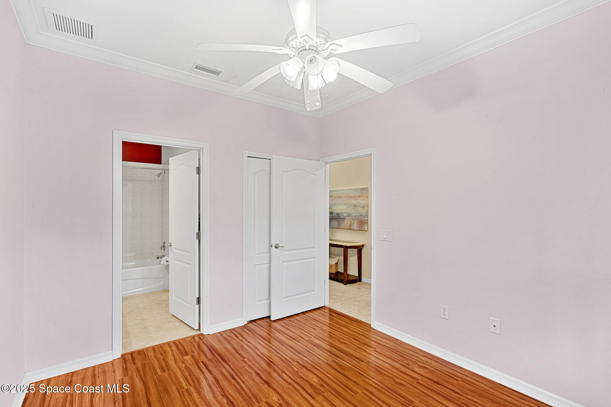 2700 Camberly Circle Melbourne, FL 32940 - Photo 18 of 50 a bedroom with a bed and a chandelier fan