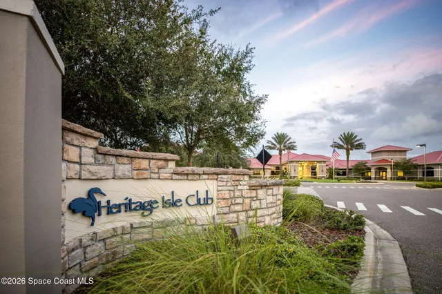 a front view of multi story residential apartment building with yard and sign board