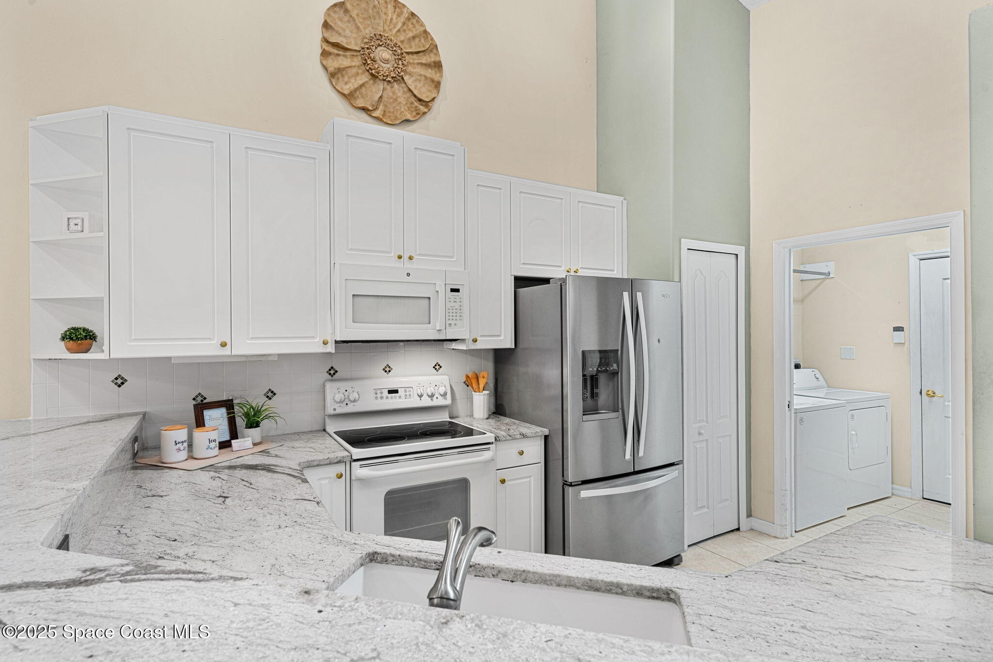 2700 Camberly Circle Melbourne, FL 32940 - Photo 10 of 50 a kitchen with a refrigerator a stove and white cabinets