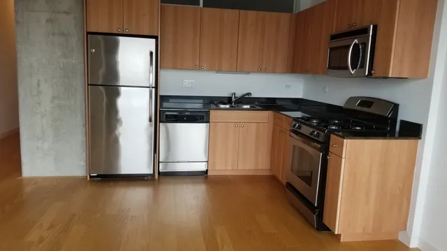 a view of a refrigerator in kitchen and wooden floor