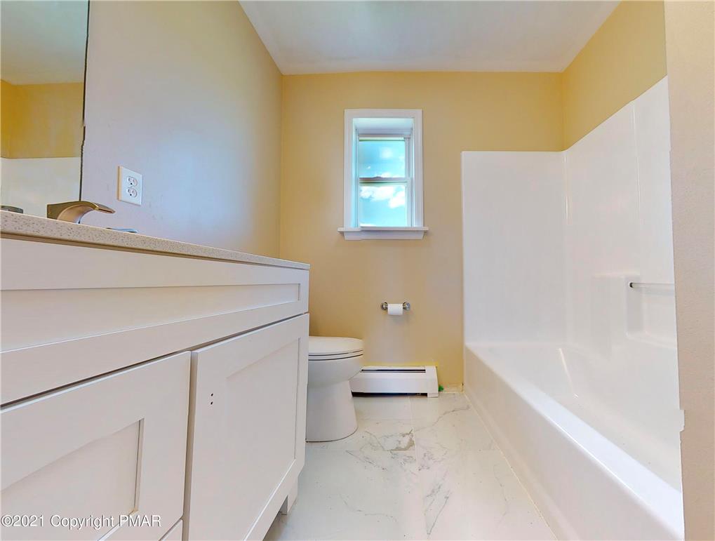 1110 Misty Ridge East Stroudsburg, PA 18302 - Photo 28 of 43 White cabinetry, bathtub, and toilet create a tidy and airy bathing space.