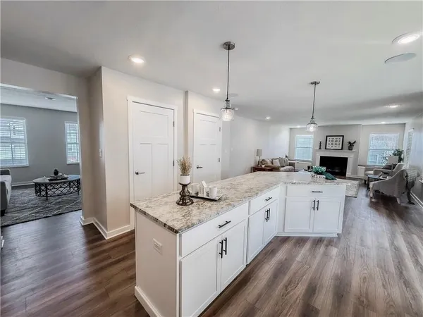 a kitchen with stainless steel appliances granite countertop a sink a stove and a wooden floors