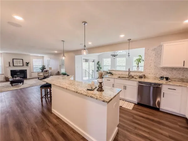 a large white kitchen with lots of counter space sink and cabinets