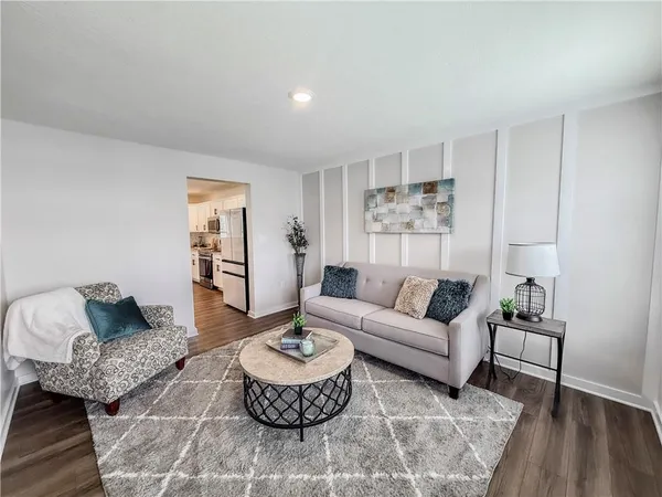 a living room with furniture and a dining table with wooden floor