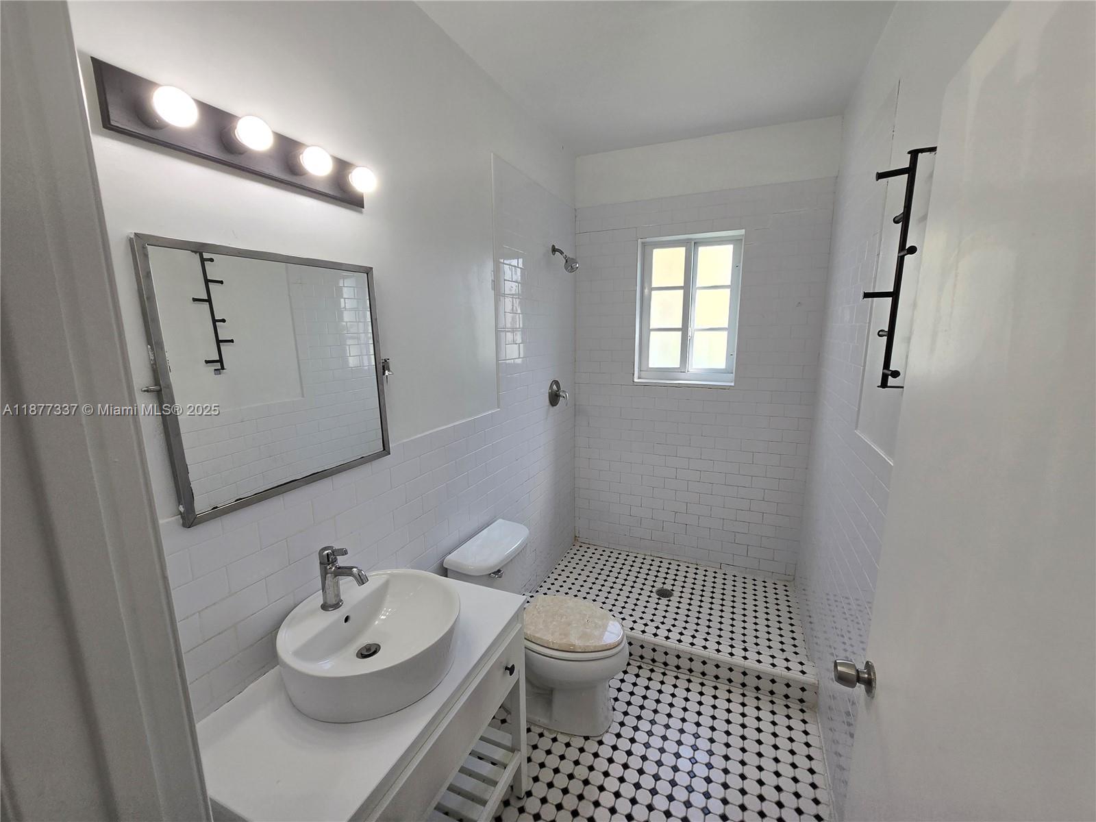 1345 Pennsylvania Avenue, Unit 2C Miami Beach, FL 33139 - Photo 15 of 18 a bathroom with a sink toilet and shower