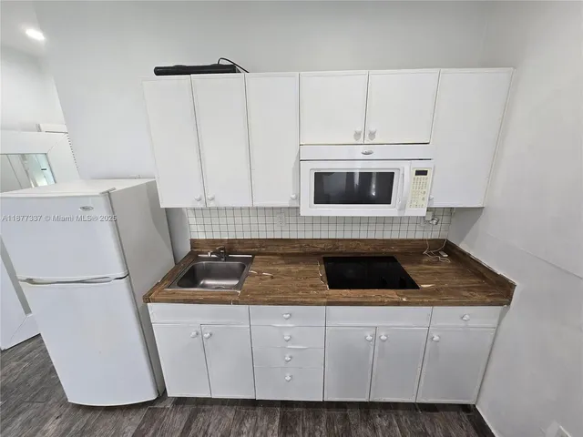 a kitchen with sink a microwave and refrigerator
