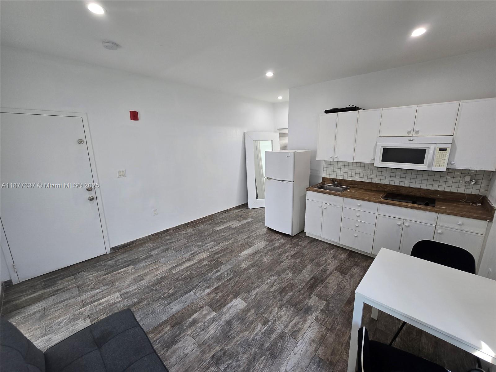 1345 Pennsylvania Avenue, Unit 2C Miami Beach, FL 33139 - Photo 5 of 18 a kitchen with sink a microwave and refrigerator