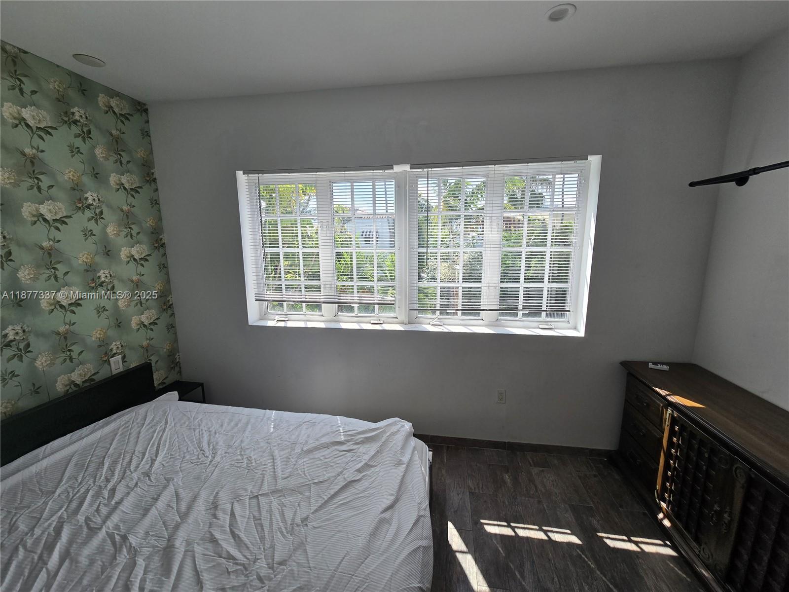 1345 Pennsylvania Avenue, Unit 2C Miami Beach, FL 33139 - Photo 9 of 18 a bedroom with a bed and wooden floor