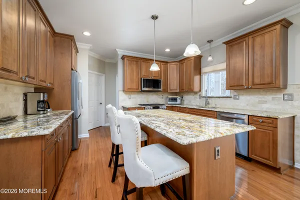 a large kitchen with cabinets chairs and chandelier