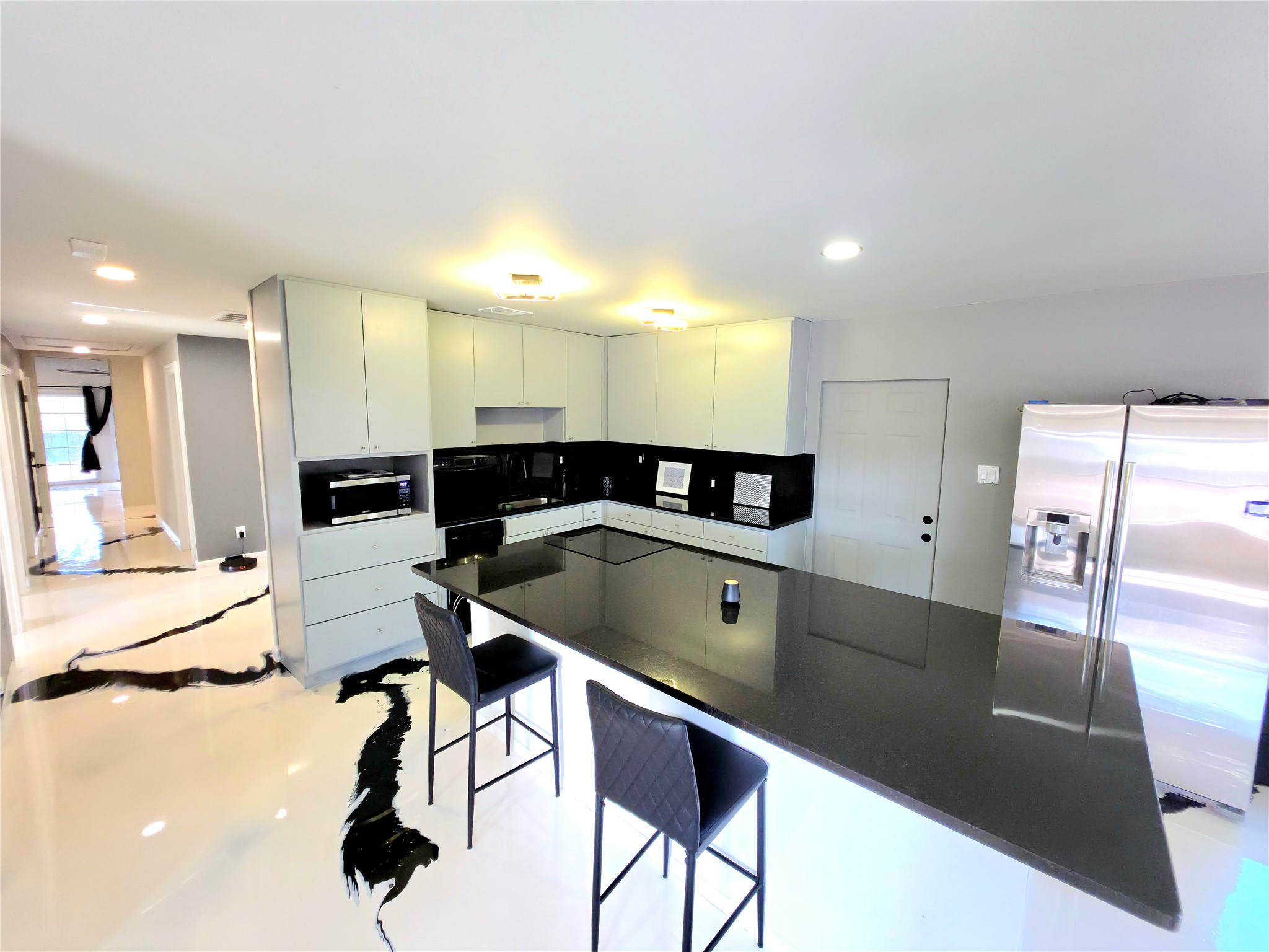 Gleaming stone countertops and a spacious breakfast bar anchor this modern gourmet workspace.