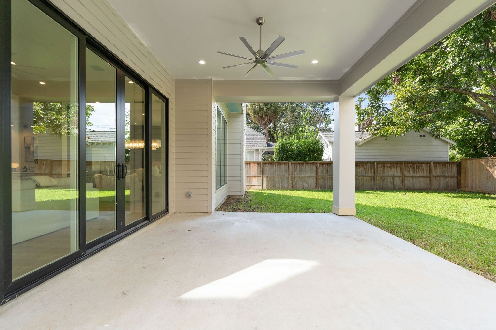 711 East 12th Street Houston, TX 77008 - Photo 12 of 47 Sliding glass doors keep the spaces connected, while a ceiling fan and gas hookup add everyday convenience. Beyond, the expansive lawn and mature corner tree create a beautiful backdrop with welcome shade.