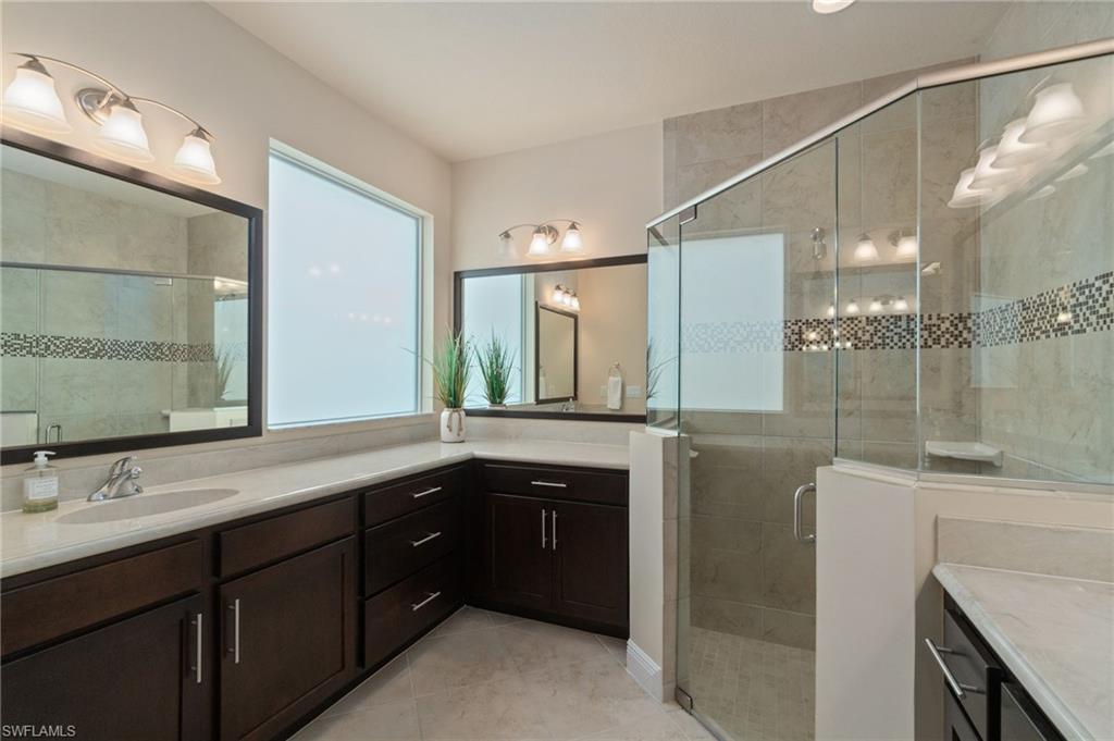 19753 Tesoro Way Estero, FL 33967 - Photo 19 of 47 a spacious bathroom with a granite countertop sink mirror and double